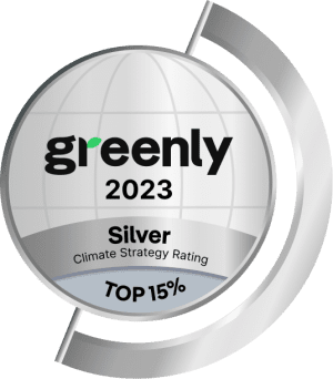 A silver badge with the text greenly 2023, Silver Climate Strategy Rating, and TOP 15%, featuring a stylized globe and curved silver bands around the edges.